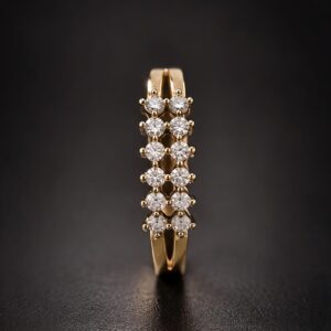 Top view of a gold double-row pavé ring with brilliant clear stones on a dark background.